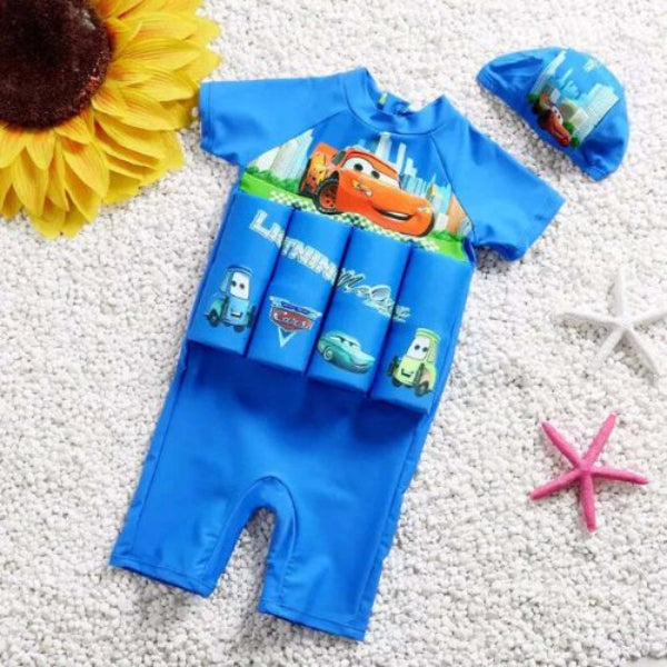 Blue children's swimsuit with cartoon characters on a textured surface with decorative elements.