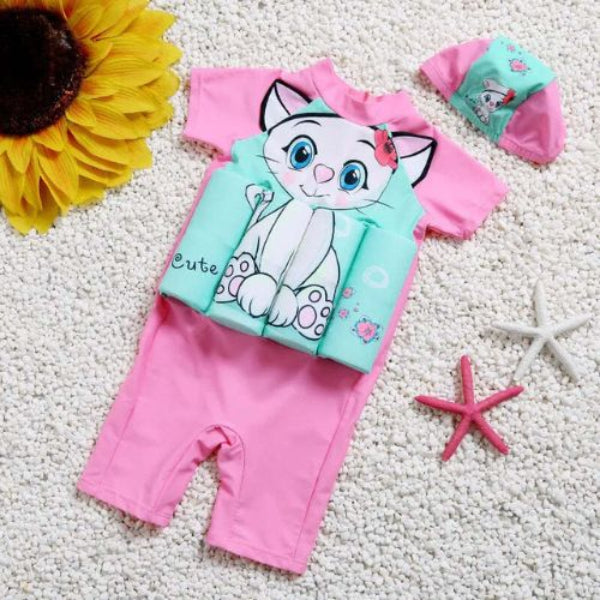 Children's outfit with cartoon cat design on a textured surface with decorative items.