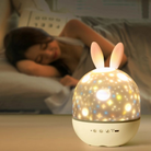 Bunny-shaped night light on a table with a person sleeping in the background