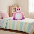 Pink unicorn plush toy on a bed with colorful striped bedding in a child's room.