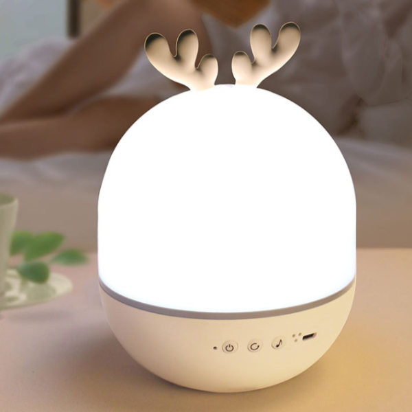 Decorative night light with reindeer antlers on a table.