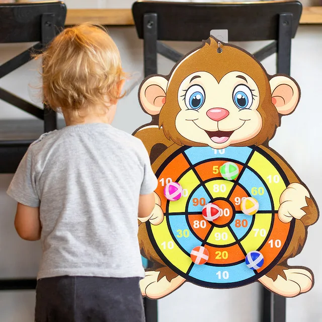 Child playing with a monkey-themed dartboard