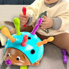 Child playing with a colorful hedgehog toy on a couch