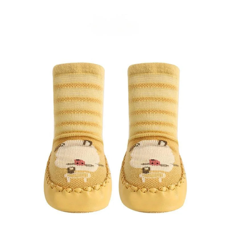 Pair of yellow baby socks with cartoon design on a white background