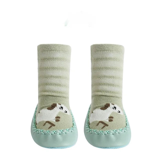 Pair of green baby socks with paw print design on a white background