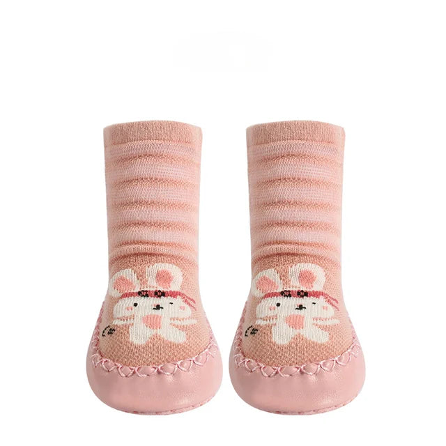 Pair of pink baby socks with cartoon cat design on a white background